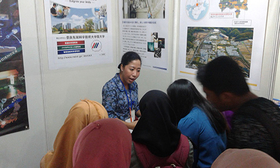 Alumni explaining NAIST to visitors