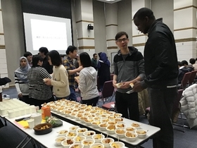 The audience enjoying nimki, dates, kheer mohon, etc. while mingling during the refreshment time.